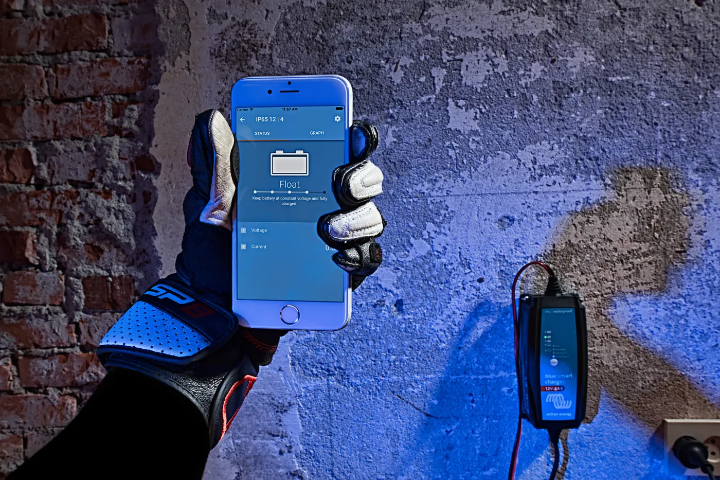 Motocyklista w rękawicach sprawdza ładowanie w telefonie